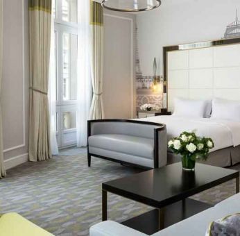 Spacious hotel suite with sofa and TV screen at the Hilton Paris Opera.