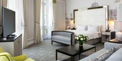 Spacious hotel suite with sofa and TV screen at the Hilton Paris Opera.