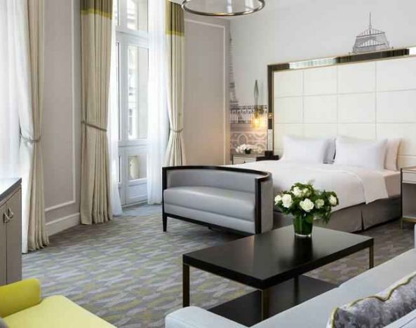Spacious hotel suite with sofa and TV screen at the Hilton Paris Opera.