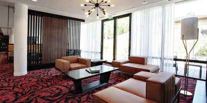 Lobby workspace with sofas at the Hampton by Hilton Toulouse Airport.