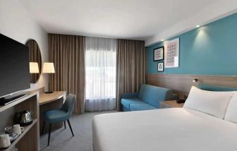 spacious king room with work and lounge area at Hampton by Hilton Torquay.