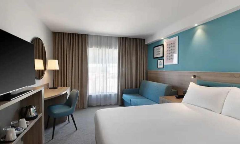 spacious king room with work and lounge area at Hampton by Hilton Torquay.