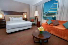 King bedroom with window and sofa at the Hilton Dallas Plano Granite Park.