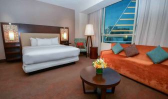 King bedroom with window and sofa at the Hilton Dallas Plano Granite Park.