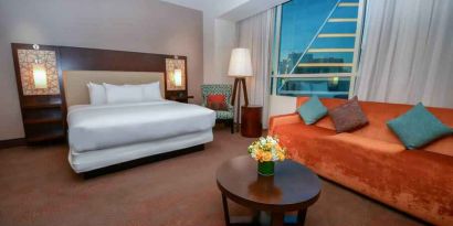 King bedroom with window and sofa at the Hilton Dallas Plano Granite Park.