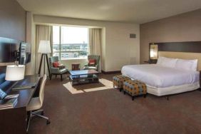 Spacious king guestroom with desk at the Hilton Dallas Plano Granite Park.