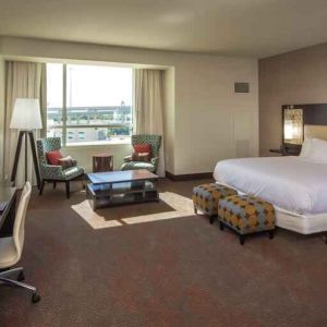 Spacious king guestroom with desk at the Hilton Dallas Plano Granite Park.