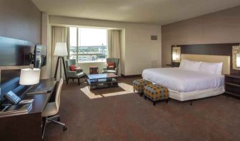 Spacious king guestroom with desk at the Hilton Dallas Plano Granite Park.