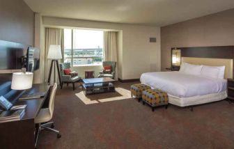 Spacious king guestroom with desk at the Hilton Dallas Plano Granite Park.