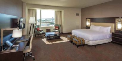 Spacious king guestroom with desk at the Hilton Dallas Plano Granite Park.