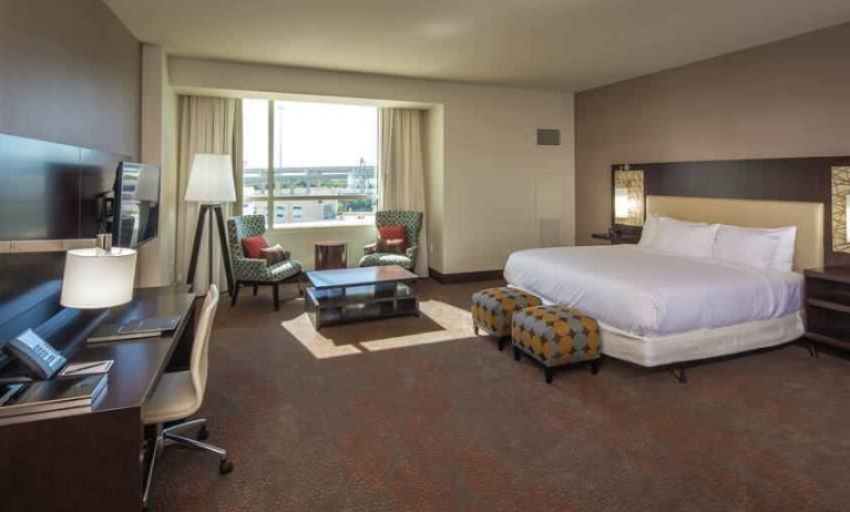 Spacious king guestroom with desk at the Hilton Dallas Plano Granite Park.