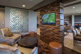 Lobby workspace with TV screen at the Hilton Dallas Plano Granite Park.