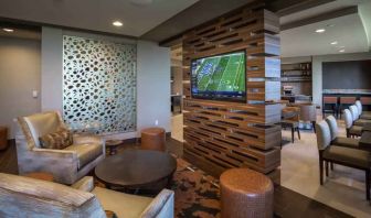 Lobby workspace with TV screen at the Hilton Dallas Plano Granite Park.