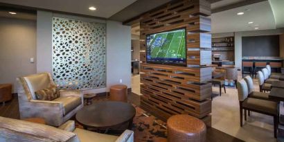 Lobby workspace with TV screen at the Hilton Dallas Plano Granite Park.