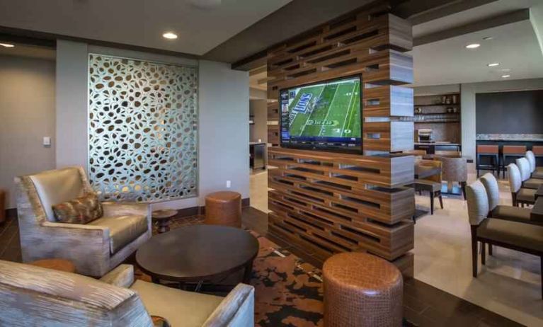 Lobby workspace with TV screen at the Hilton Dallas Plano Granite Park.