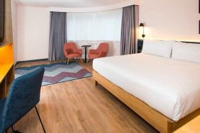 cosy king room with TV, desk, and lounge area ideal for working remotely at Hampton by Hilton London Park Royal.