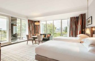 Twin room with large windows and desk at the Hilton Amsterdam.