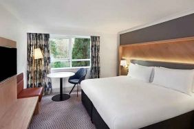 spacious king room with TV, comfortable work desk and natural light at Hilton Cobham.