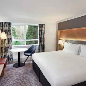 spacious king room with TV, comfortable work desk and natural light at Hilton Cobham.