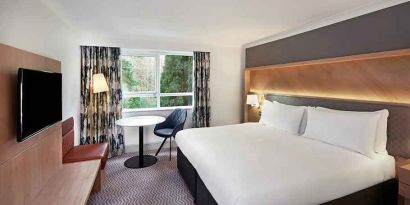 spacious king room with TV, comfortable work desk and natural light at Hilton Cobham.