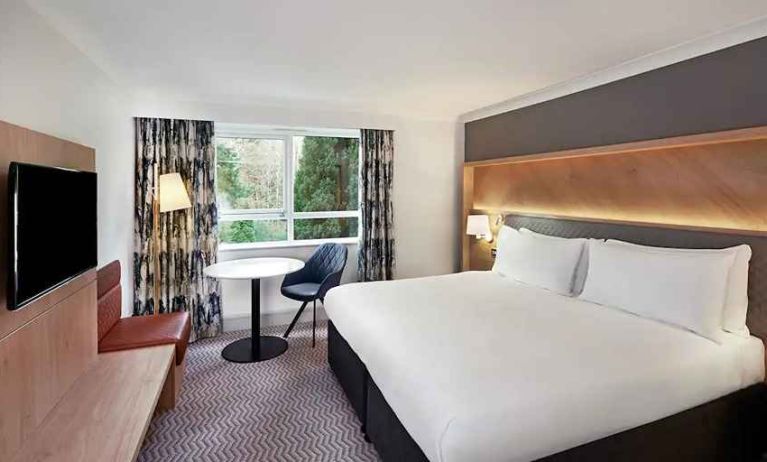 spacious king room with TV, comfortable work desk and natural light at Hilton Cobham.