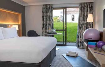 lovely king room with yoga and strateching equipment and garden view at Hilton Cobham.