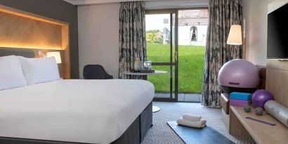 lovely king room with yoga and strateching equipment and garden view at Hilton Cobham.