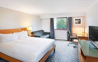 spacious king room with TV, comfortable work desk and natural light at Hilton London Watford.