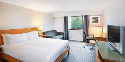 Spacious king room with TV, comfortable work desk and natural light at Hilton London Watford.