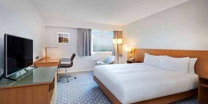 Comfortable king room with TV and work desk at Hilton London Watford.