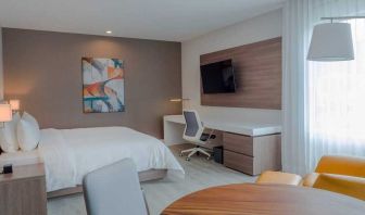 luxurious king suite with TV, work desk, and dining area at Hilton Garden Inn Santa Ana San Jose.