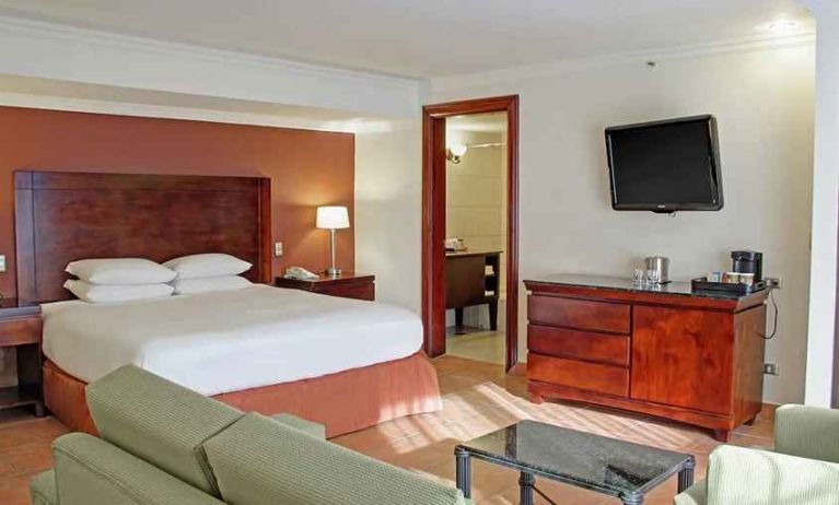 luxurious king suite with TV, work desk, and lounge area at DoubleTree by Hilton Hotel Cariari San Jose - Costa Rica.