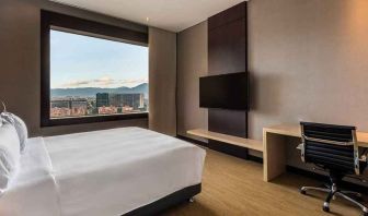 comfortable king room with TV, work desk, and natural light at DoubleTree by Hilton Bogota Salitre AR.