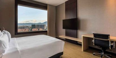 comfortable king room with TV, work desk, and natural light at DoubleTree by Hilton Bogota Salitre AR.