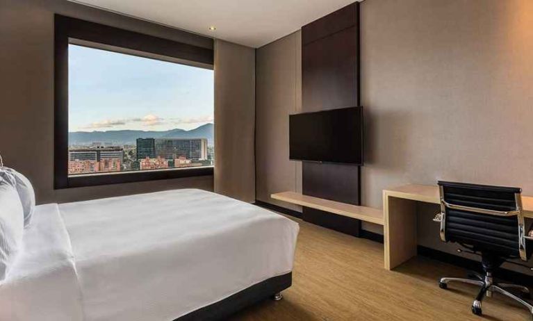 comfortable king room with TV, work desk, and natural light at DoubleTree by Hilton Bogota Salitre AR.