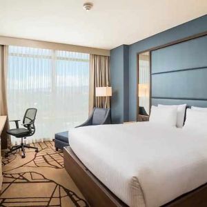 comfortable king room with TV, work desk, and natural light at Hilton Garden Inn Bogota Airport.