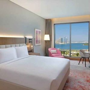 beautiful king room with work desk, TV, and water/city views at DoubleTree by Hilton Sharjah Waterfront Hotel & Residences.