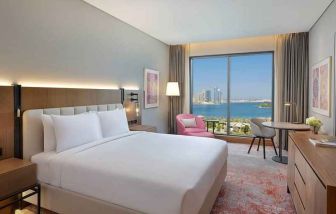 beautiful king room with work desk, TV, and water/city views at DoubleTree by Hilton Sharjah Waterfront Hotel & Residences.