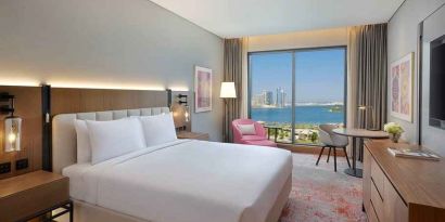 beautiful king room with work desk, TV, and water/city views at DoubleTree by Hilton Sharjah Waterfront Hotel & Residences.