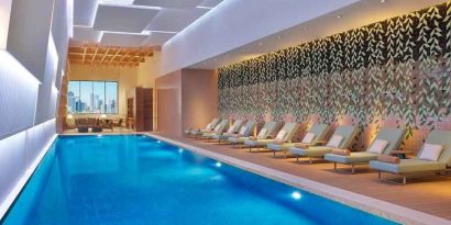 gorgeous indoor pool with pool beds at DoubleTree by Hilton Sharjah Waterfront Hotel & Residences.