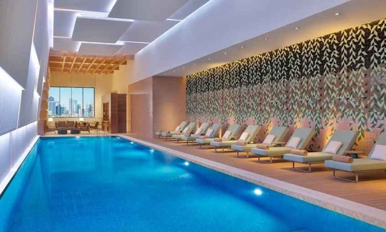 gorgeous indoor pool with pool beds at DoubleTree by Hilton Sharjah Waterfront Hotel & Residences.