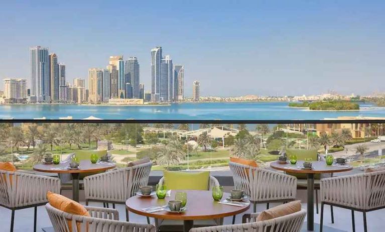 lovely outdoor terrace with gorgeous water/city views ideal as a coworking space at DoubleTree by Hilton Sharjah Waterfront Hotel & Residences.