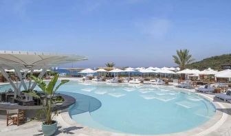 beautiful outdoor pool surrounded by seating and sun beds at Susona Bodrum, LXR Hotels & Resorts.