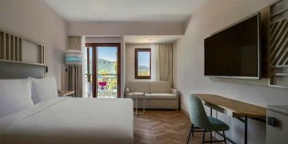 spacious king room with lots of natural light, sea view, TV, and work desk at DoubleTree by Hilton Bodrum Isil Club Resort.