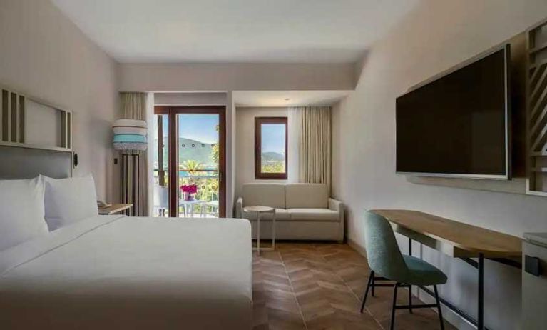 spacious king room with lots of natural light, sea view, TV, and work desk at DoubleTree by Hilton Bodrum Isil Club Resort.