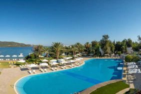 stunning outdoor pool surrounded by sun beds and pool umbrellas at DoubleTree by Hilton Bodrum Isil Club Resort.