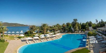 stunning outdoor pool surrounded by sun beds and pool umbrellas at DoubleTree by Hilton Bodrum Isil Club Resort.