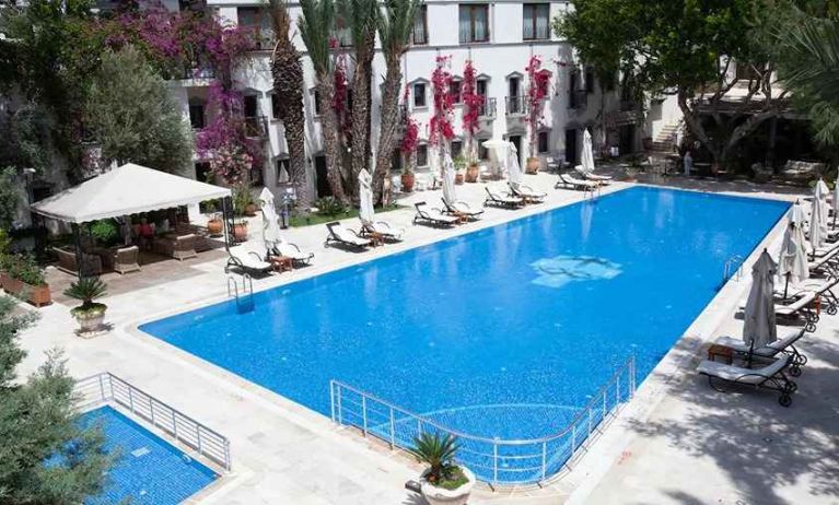 beautiful outdoor pool surrounded by seating and sun beds at DoubleTree by Hilton Bodrum Marina Vista.