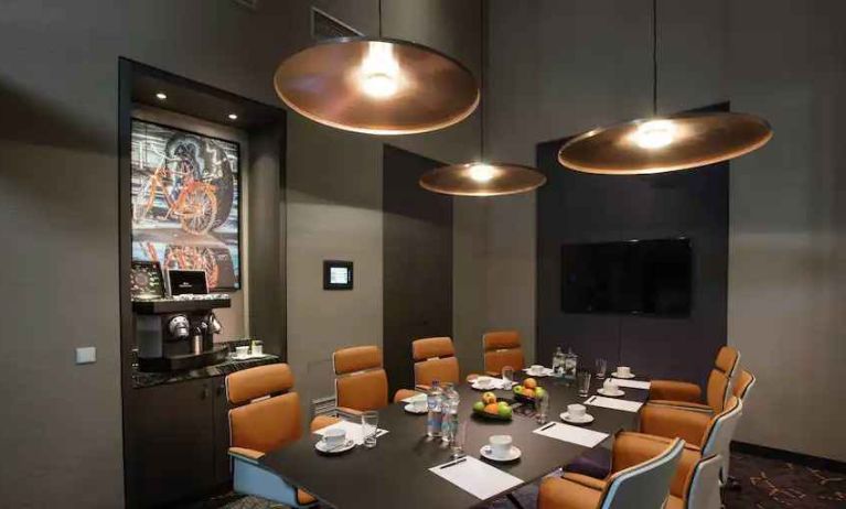 Meeting room with TV screen and coffee machine at the Hilton Amsterdam Airport Schiphol.