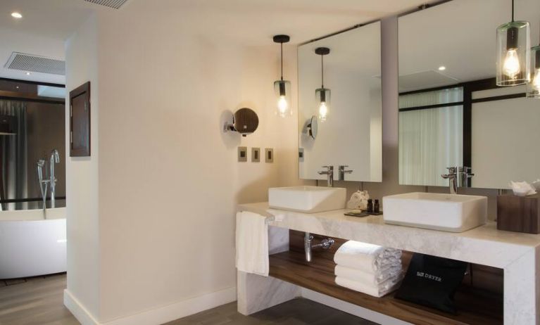 Bathroom with two sinks and mirrors at the Hotel 1970 Guadalajara, Curio Collection by Hilton.